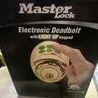 Master Lock Electronic Keyless Deadbolt With Light Up Pad Gold New. Price: $59.99.